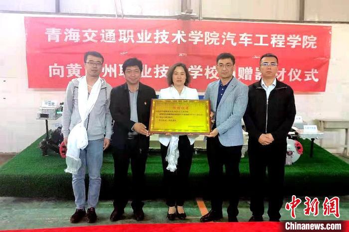 圖為李富香(中)代表學(xué)校為州縣技校捐贈(zèng)器材。(資料圖) 青海省教育廳供圖