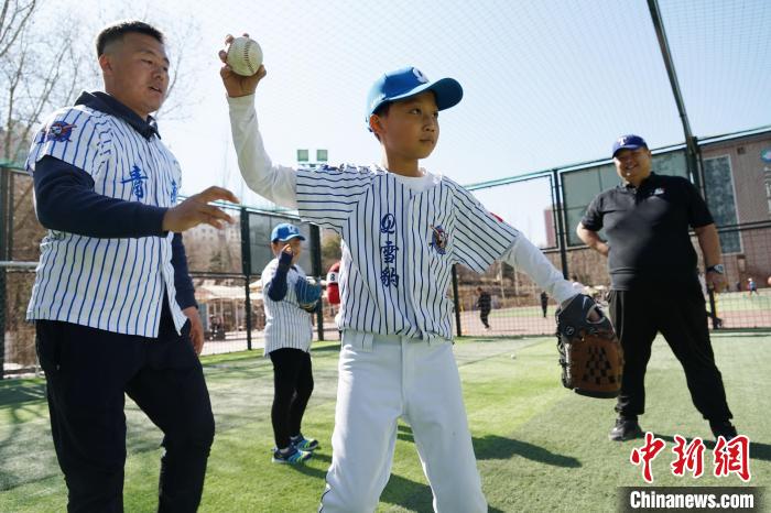 圖為教練指導(dǎo)小棒球手?jǐn)S球技術(shù)?！●R銘言 攝