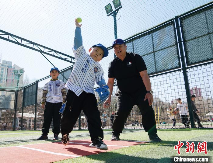 圖為來自臺(tái)灣的棒球教練劉興鴻(右)指導(dǎo)小棒球手?jǐn)S球技術(shù)。　馬銘言 攝