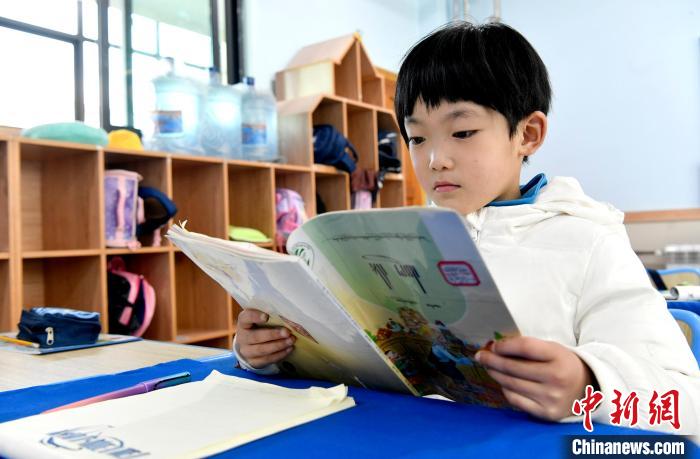 3月14日，西藏拉薩市第一小學(xué)一年級六班學(xué)生丁增樂吉在閱讀藏語課本。　李林 攝