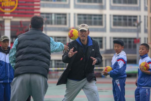 在高原上教孩子們打手球，“慢慢兒來，甭著急！”