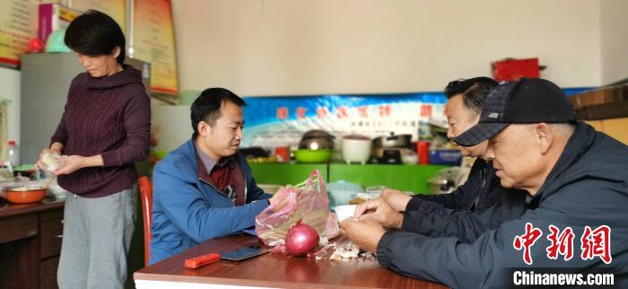 圖為扶貧路上“臨時(shí)一家人”準(zhǔn)備午餐?！∥航ㄜ?攝