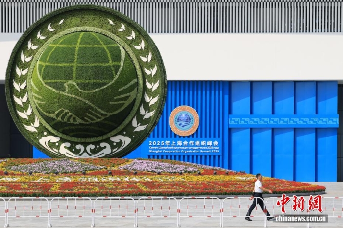 8月31日，天津，一名工作人員從2025年上海合作組織峰會主會場外的景觀花壇旁經(jīng)過。當日，2025年上海合作組織峰會在天津舉行。<a target='_blank' href='/'><p  align=