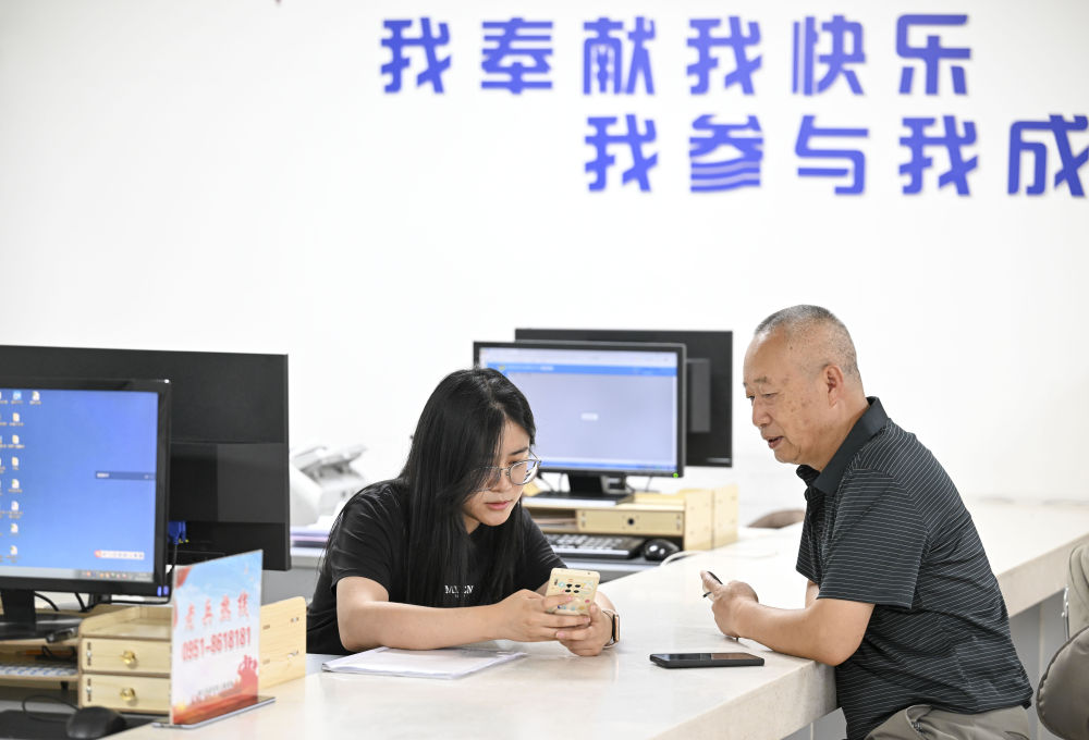 2024年6月20日，在寧夏銀川市金鳳區(qū)長(zhǎng)城花園社區(qū)黨群服務(wù)中心，工作人員幫助居民辦理業(yè)務(wù)。圖片來源 新華社