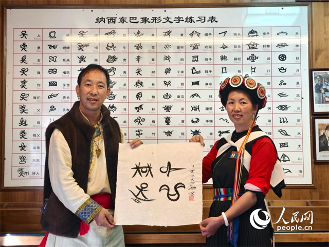 人民網(wǎng)“行進中國”云南調(diào)研采訪團走進麗江，和閏元現(xiàn)場用東巴文寫下“行進中國”。人民網(wǎng)記者 符皓攝