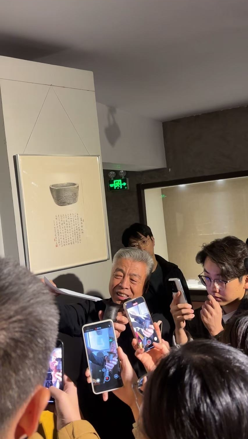 黑陶邢文化博物館館長邢葆東展示兩張相疊的A4紙，向記者解釋此為杯口的厚度。