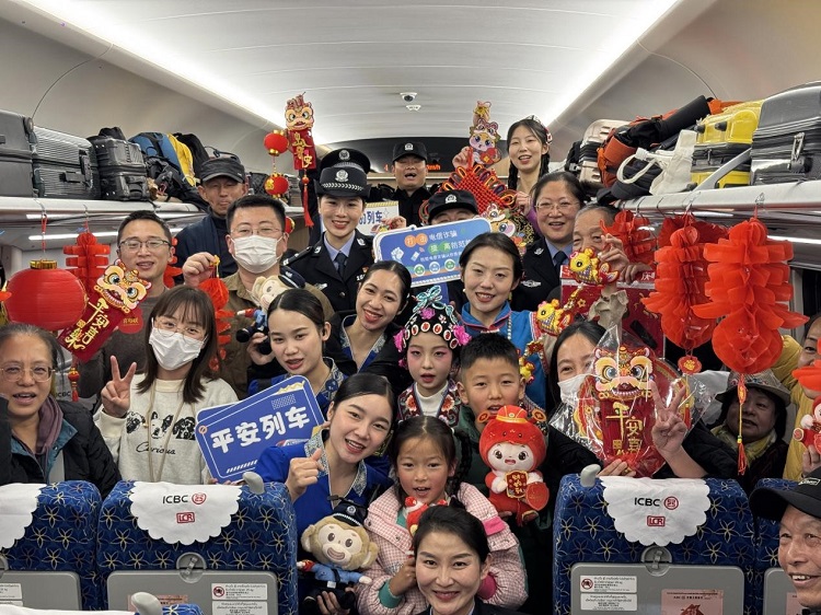 春節(jié)期間，在中老鐵路磨萬（磨丁—萬象）段，鐵路客運員工與乘客合影留念。李加勇攝