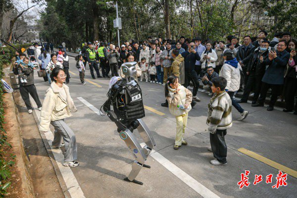 “智警小珞”人形機(jī)器人和小朋友們斗舞。長江日報(bào)記者史偉 攝