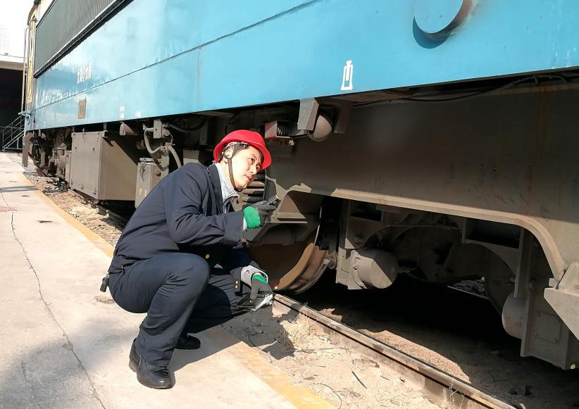 韓文盛全神貫注檢查機車走行部。