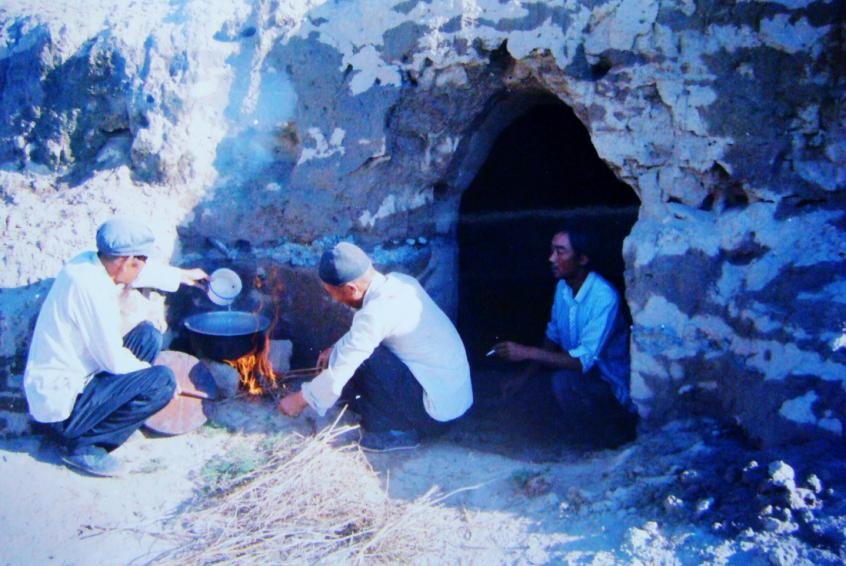 1983年，“六老漢”一代治沙人在“地窩子”生活做飯。新華社發(fā)（八步沙林場(chǎng)供圖）