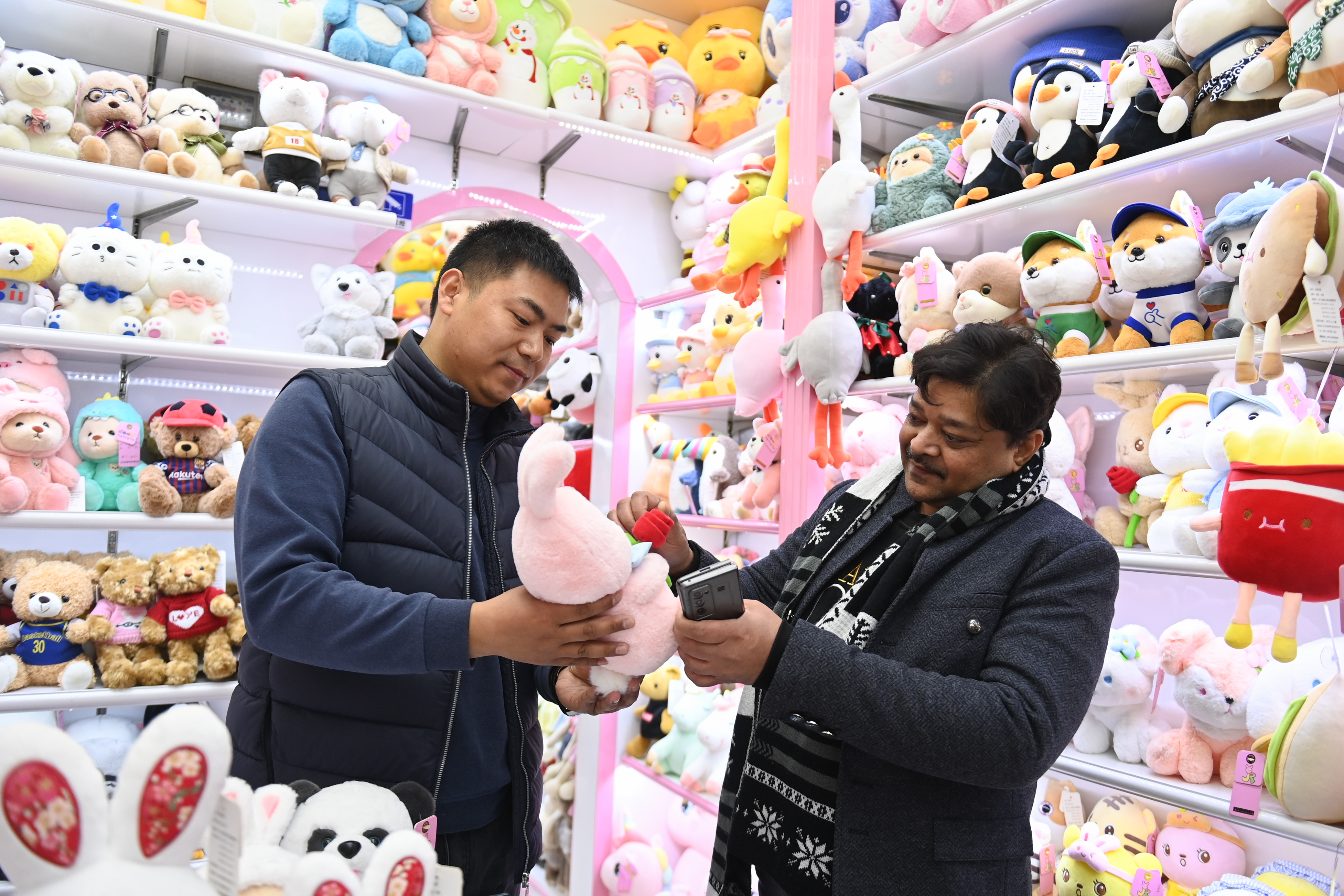 2023年2月2日，來(lái)自印度的客商（右）在義烏國(guó)際商貿(mào)城的一家玩具店鋪內(nèi)選購(gòu)。