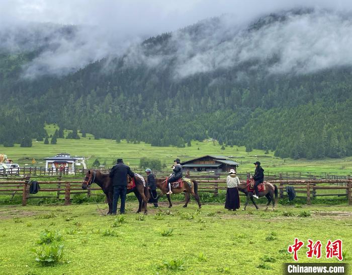 6月10日，游客在魯朗小鎮(zhèn)高山牧場景區(qū)體驗騎馬?！∪轿木?攝