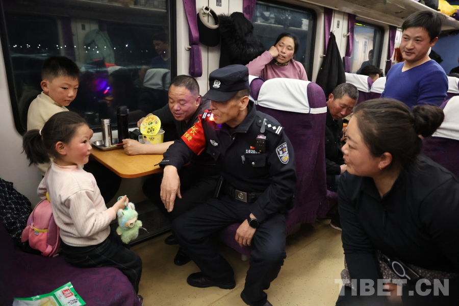 乘警長左紅彬在巡視車廂間隙，向攜帶兒童的旅客專門叮囑安全注意事項。.JPG