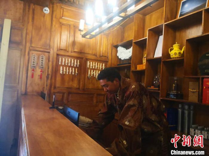 圖為桑杰才讓用電腦處理財務(wù)?！∈缝o靜 攝