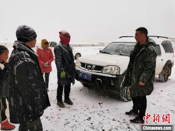 圖為扎西鬧吾(右一)與當(dāng)?shù)啬翍?hù)交談。郵儲(chǔ)銀行青海省分行供圖