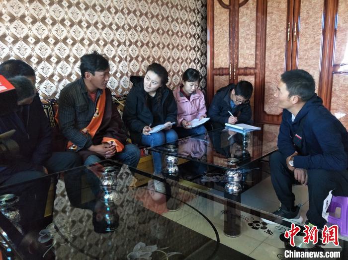 圖為調(diào)查組工作人員正在入戶調(diào)查?！∑钤鲚?攝
