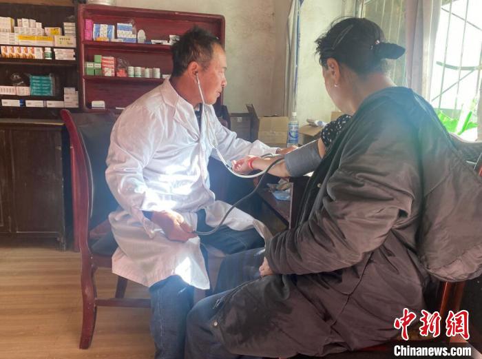 索木滾(左)為村民看病?！∪捞量h委宣傳部供圖