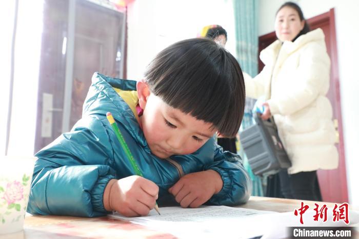 孩子們?cè)诩议T口上學(xué)，是楊周馬草搬入蘭州新家最為開心的事情。小女兒楊洋正在學(xué)習(xí)寫數(shù)字?！∥航ㄜ?攝