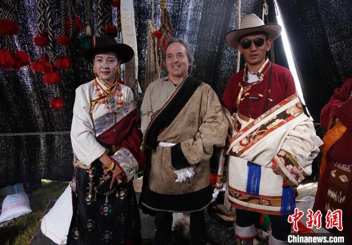 圖為一名外籍?dāng)z影師(中)身穿藏服和藏族民眾合影留念?！●R銘言 攝