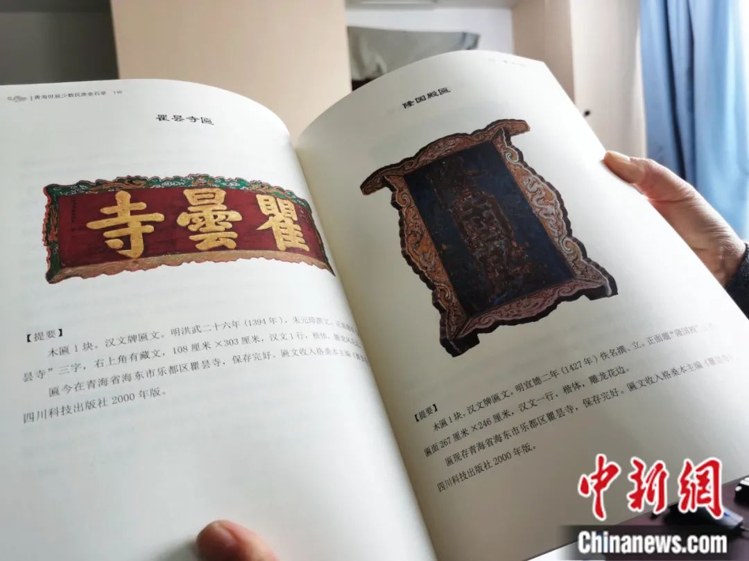 古籍保護人員展示介紹明代朱元璋撰寫的青海瞿曇寺匾(左)的出版書籍。張?zhí)砀?攝