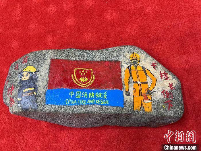 圖為玉樹消防指戰(zhàn)員創(chuàng)作的石頭畫作品《我有一個(gè)特點(diǎn)“不擅長(zhǎng)倒下”》?！O瑞祥 攝