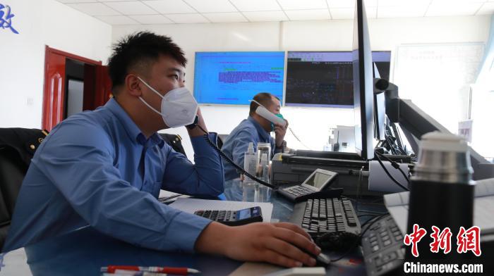 圖為貨運調度人員與外勤工作人員聯(lián)系掌握車輛裝載情況?！±钌?攝