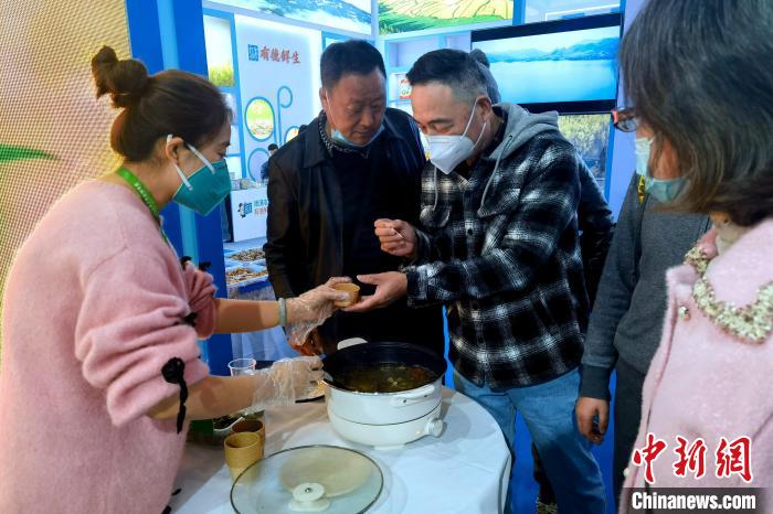 圖為杭州市民品嘗茶卡羊肉。　李雋 攝