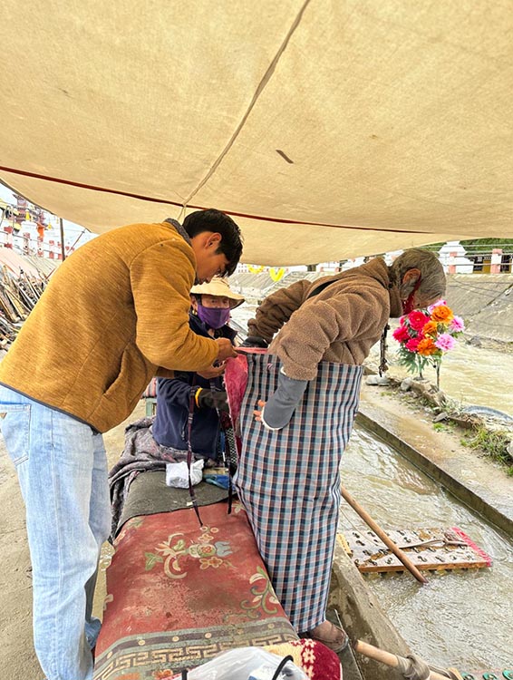 扎西奪爾登為路邊老人送去保暖圍腰。阿壩州文明辦供圖