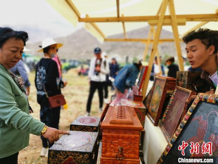 圖為拉薩市民在特色農(nóng)畜產(chǎn)品展示展銷會上選購商品?！垈?攝