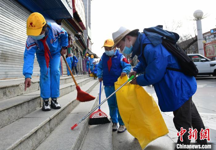圖為拉薩市小學生打掃街道?！∝暩聛硭?攝