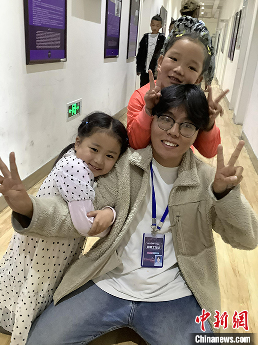 “Z世代”旦真旺加認(rèn)為，拉薩是一座開放與包容的城市，記憶中的拉薩是彩色的。2021年，旦真旺加從浙江大學(xué)漢語(yǔ)言文學(xué)專業(yè)畢業(yè)后，他選擇回到拉薩，成為一名漢語(yǔ)文實(shí)習(xí)助教。圖為8月4日，旦真旺加在課間陪學(xué)生玩耍。 <a target='_blank' ><p  align=