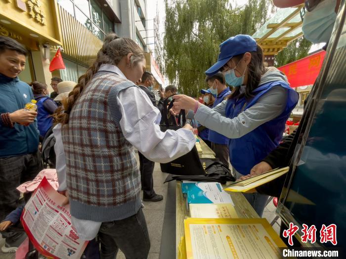圖為志愿者為市民發(fā)放網(wǎng)絡(luò)安全宣傳手冊(cè)?！≈x牧 攝