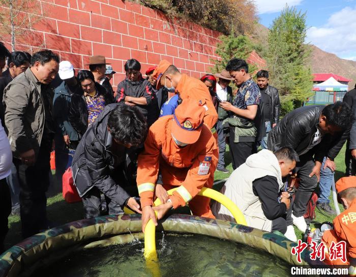 圖為森林消防員為護(hù)林員講解滅火裝備的使用方法。　昌都市森林消防支隊(duì) 供圖