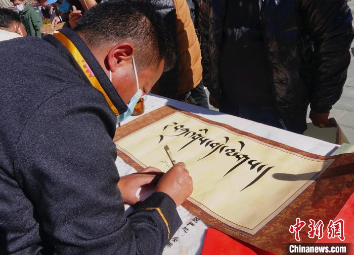 圖為書(shū)法家展示藏文書(shū)法?！∪轿木?攝