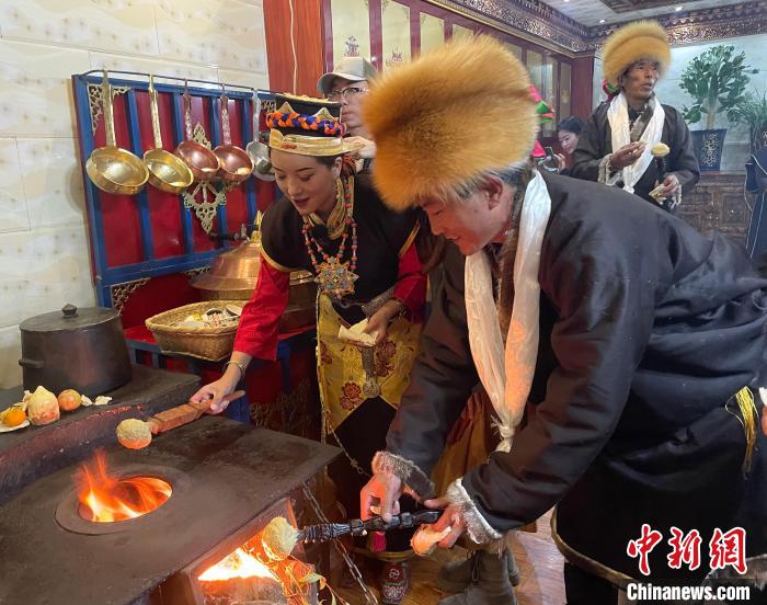 圖為人們?cè)诨鹕峡竟?jié)日美食“結(jié)達(dá)”?！∪轿木?攝