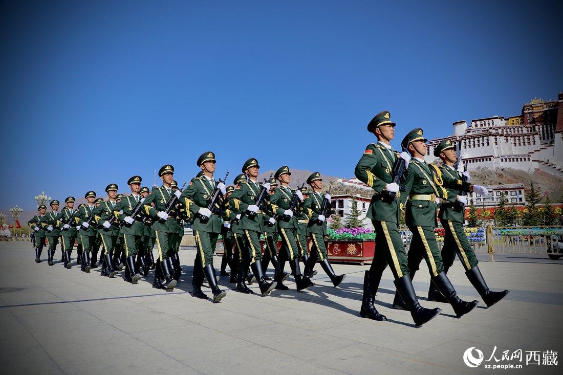 國旗護(hù)衛(wèi)隊(duì)隊(duì)員緊握鋼槍，踏著威武雄壯的步伐，走向國旗臺(tái)。人民網(wǎng) 次仁羅布攝