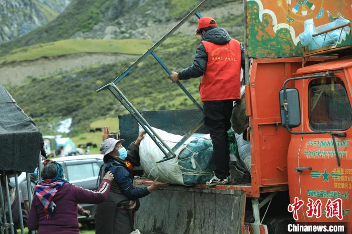 圖為工作人員幫助牧民們卸家具?！÷蹇?攝