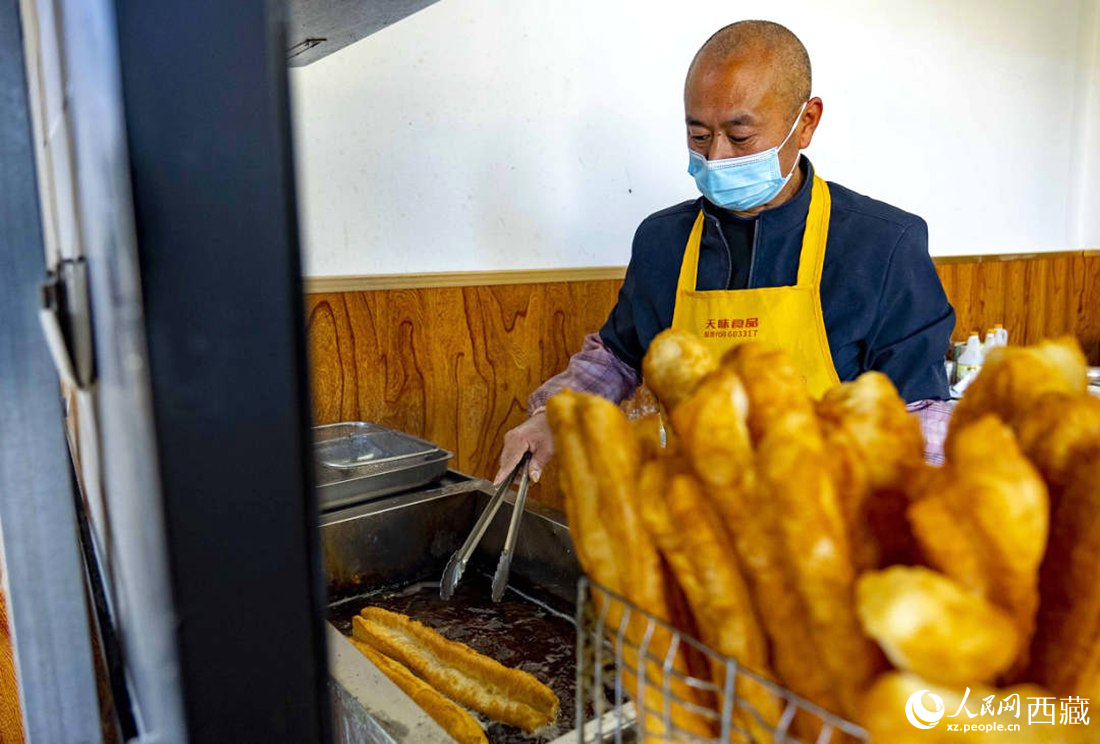 早餐店老板正在炸油條。人民網(wǎng) 次仁羅布攝