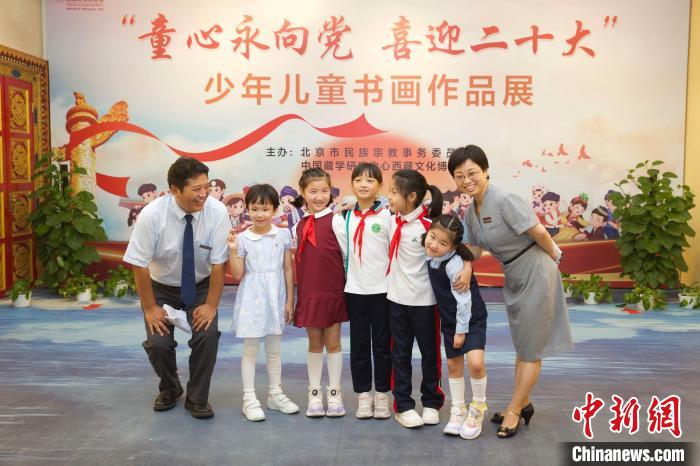 圖為與會嘉賓與入選畫作的“小作者”們在展覽上合影?！≈袊貙W研究中心供圖