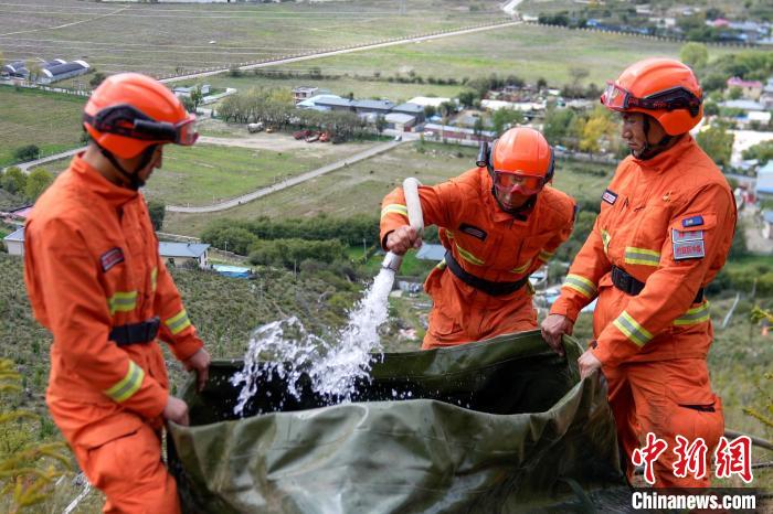 技能大練兵過(guò)程中，消防員在陡坡上向蓄水池注水?！±顕?guó)燾 攝