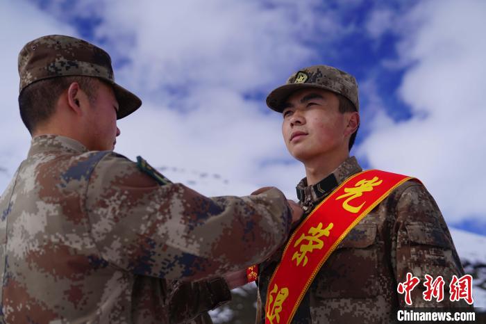 排長王朝偉(圖左)給退伍老兵佩戴大紅花?！∥鞑厣侥宪姺謪^(qū)某團(tuán)供圖