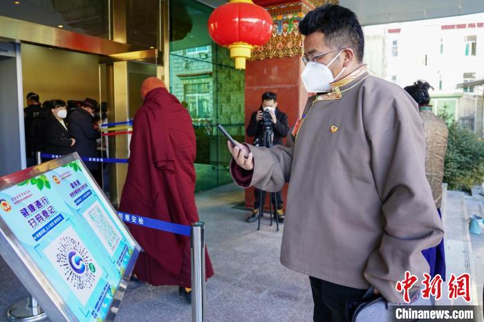 圖為政協(xié)委員掃場所碼進入會場。　江飛波 攝