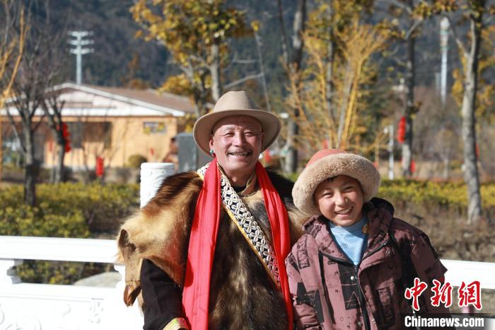 圖為林芝市巴宜區(qū)布久鄉(xiāng)仲果村村民桑杰與孫子一起參加藏歷新年活動(dòng)?！埩?攝