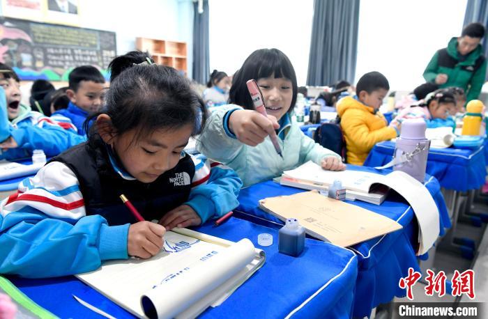 3月14日，西藏拉薩市第一小學(xué)一年級(jí)六班學(xué)生白瑪朗珍(圖左)在藏語(yǔ)文課上書(shū)寫(xiě)藏文?！±盍?攝