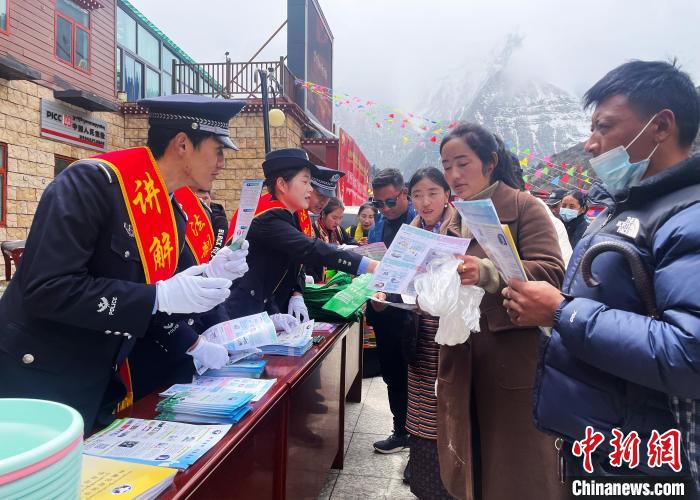 圖為山南玉麥邊境派出所民警為轄區(qū)群眾發(fā)放法律知識宣傳單?！＄婗?　攝