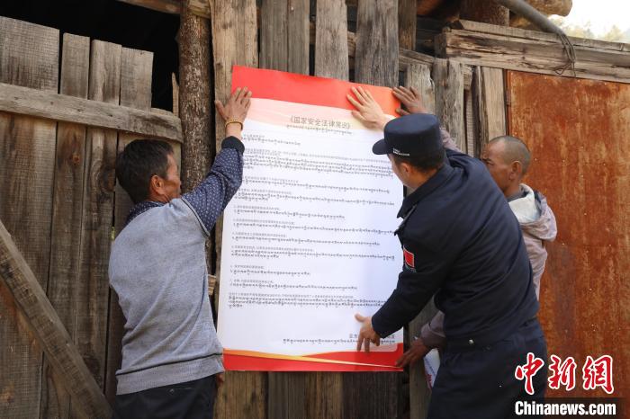圖為亞東邊檢站民警與駐地邊民群眾共同張貼國(guó)家安全知識(shí)教育海報(bào)?！問|邊檢站 供圖