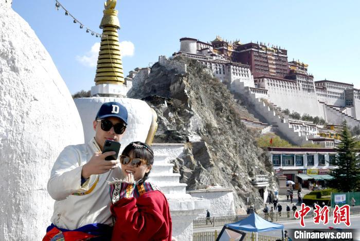 4月17日，游客身著藏式元素服裝在拉薩布達拉宮觀景臺拍照留念?！±盍?攝