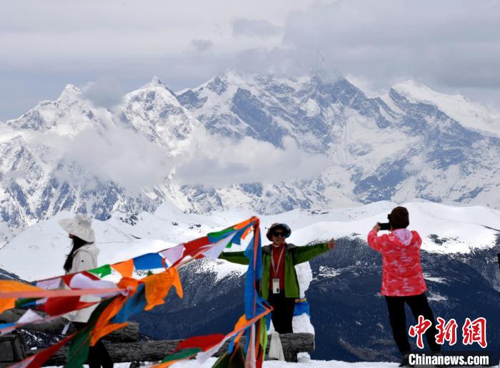 圖為5月14日，西藏林芝色季拉山觀景臺，游客與南迦巴瓦峰合影。　李林 攝