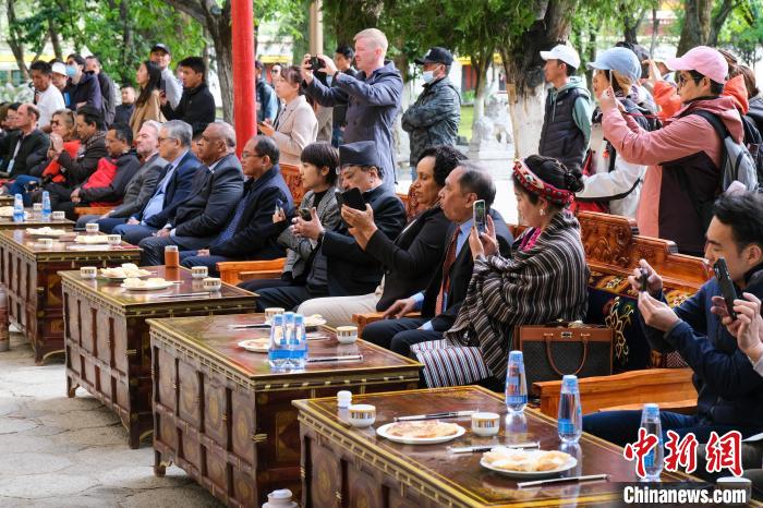 5月19日，中外嘉賓在羅布林卡和游客一起觀看藏戲。　江飛波 攝