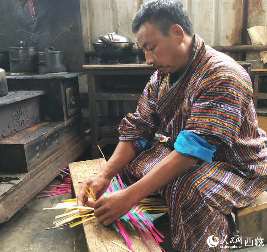 門巴族漢子愛明正在編織藤竹品。